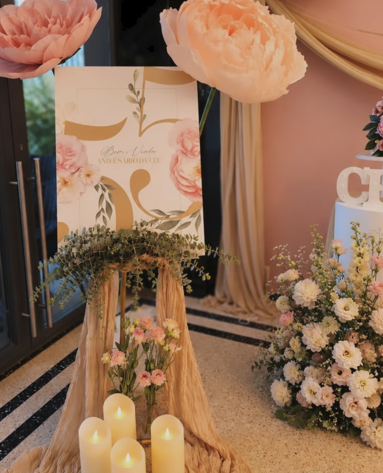 Entrada do aniversário com placa de boas-vindas, flores e velas